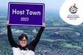 Eine Teilnehmerin der Special Olypics hält ein Schild hoch: Host Town 2023
