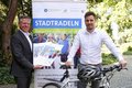 Landrat Hans-Jürgen Petrauschke und Michael Ruß mit Plakat und Fahrrad