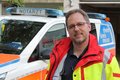Marc Zellerhoff in Rettungsdienstjacke vor Notarztwagen des Rhein-Kreises Neuss