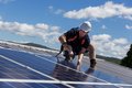 Ein Mann befestigt Solarzellen auf einem Dach