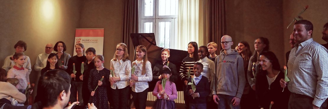 Gruppenfoto vieler Kinder mit verschiedenen Instrumenten.