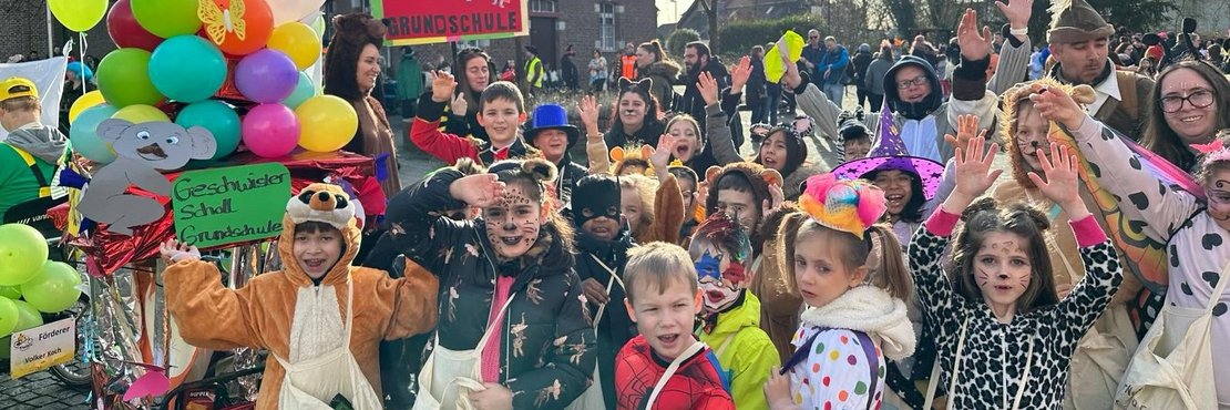 Gruppe kostümierter Kinder. Im Hintergrung bunte Luftballons.