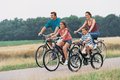Eine 4-köpfige Familie mit Fahrrädern auf einem Feldweg