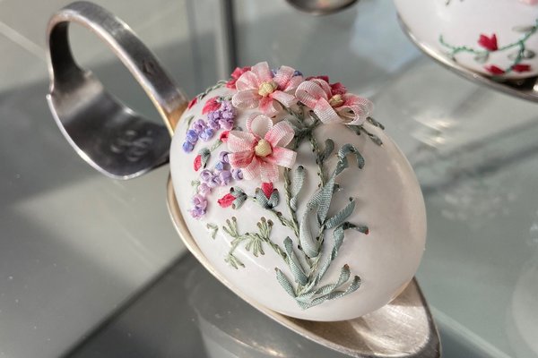 Bestickte Ostereier mit Blumenmotiven auf Löffeln in der Vitrine von Elisabeth Klein