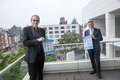 Landrat Hans-Jürgen Petrauschke und Thomas Kolaric auf einer Dachterrasse halten Plakate