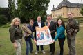 Personengruppe hält ein Plakat zum Familienfest auf dem Gelände von Schloss Dyck