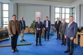 Landrat Hans Jürgen Petrauschke mit Teilnahmern stehen mit Abstand im Kreissitzungssaal des Kreishauses Grevenbroich