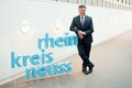 Landrat Hans-Jürgen Petrauschke lehnt an einem 3D-Logo des Rhein-Kreises Neuss