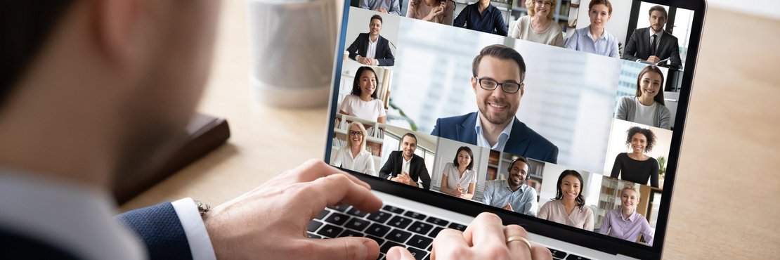 Mann sitzt vor einem Laptop mit Video-Konferenz